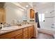 Bathroom with double vanity, granite countertops, and a bathtub with shower at 2020 Routt St, Lakewood, CO 80215