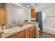 Bathroom with double vanity, granite countertops, and a bathtub with shower at 2020 Routt St, Lakewood, CO 80215