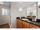 Bright bathroom featuring a shower with glass door, tiled floor, and granite countertop at 2020 Routt St, Lakewood, CO 80215