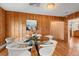 Cozy dining room featuring a glass table, unique white chairs and wood paneled walls at 2020 Routt St, Lakewood, CO 80215