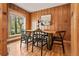 Dining room featuring wood paneled walls, hardwood floors, and a large window at 2020 Routt St, Lakewood, CO 80215