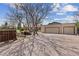 Three-car garage on gravel driveway with mature trees and blue sky at 2020 Routt St, Lakewood, CO 80215