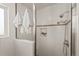 Updated shower featuring white tile, decorative tile accents, and dual shower heads at 2020 Routt St, Lakewood, CO 80215