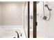 A shower with a white tile surround, a glass door, and a shower head at 17947 E 95Th Ave, Commerce City, CO 80022