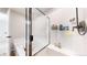 A bathtub with a glass door, a shower head, and a tiled wall at 17947 E 95Th Ave, Commerce City, CO 80022