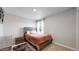 A cozy bedroom with a bed, a nightstand, and a window at 17947 E 95Th Ave, Commerce City, CO 80022