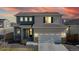 Charming two-story home featuring mixed siding, stone accents, an attached two-car garage, and beautiful sunset sky at 17947 E 95Th Ave, Commerce City, CO 80022