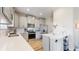 Modern kitchen featuring gray cabinets, stainless steel appliances, quartz countertops, and tile backsplash at 17947 E 95Th Ave, Commerce City, CO 80022