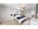 Bright main bedroom features neutral colors, large bed, ceiling fan, and natural light at 17947 E 95Th Ave, Commerce City, CO 80022