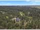 An aerial shot captures the beauty of a wooded acreage with a sprawling residence and winding driveway at 1972 Gold Camp Way, Franktown, CO 80116