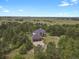 An aerial view features a well-maintained home with an attached garage in a serene, wooded landscape at 1972 Gold Camp Way, Franktown, CO 80116