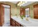 Bathroom featuring a double vanity with gold fixtures, decorative wallpaper and a large mirror for added light at 1972 Gold Camp Way, Franktown, CO 80116