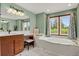 Bathroom with a soaking tub, vanity with seating and large window with natural light at 1972 Gold Camp Way, Franktown, CO 80116