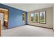 Bright bedroom featuring blue accent wall, plush carpeting, and natural light streaming through three large windows at 1972 Gold Camp Way, Franktown, CO 80116