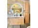 Modern bathroom featuring round backlit mirror and wood grain vanity at 5563 E Jefferson Ave, Denver, CO 80237