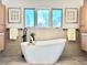 Bathroom features a freestanding tub, wood cabinets, and natural light from multiple windows at 5563 E Jefferson Ave, Denver, CO 80237