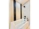 Modern bathroom with a built-in bathtub and stylish black and tan tile at 5563 E Jefferson Ave, Denver, CO 80237