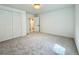 This bedroom features neutral carpet, closet, and door to a hallway at 5563 E Jefferson Ave, Denver, CO 80237