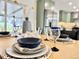 Dining table setting featuring layered plates, blue-rimmed glasses, and natural light in a modern dining room at 5563 E Jefferson Ave, Denver, CO 80237