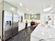 Spacious kitchen with stainless steel appliances, sage cabinets, white countertops, and trendy black marble flooring at 5563 E Jefferson Ave, Denver, CO 80237