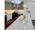 Open kitchen view featuring a large marble island, sage cabinets, stainless appliances, and stylish decor at 5563 E Jefferson Ave, Denver, CO 80237
