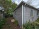 Side of a gray sided house with white trim, windows, and a chain link fence surrounded by green vegetation at 1717 Oswego St, Aurora, CO 80010