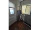 A gray water heater with copper pipes is in a room with wood flooring and a window with blinds at 1717 Oswego St, Aurora, CO 80010