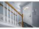 Inviting entryway featuring a classic white door with half-moon window and staircase with white banister and wood railing at 2823 Jasmine St, Denver, CO 80207