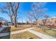 Brick building with a spacious front yard, sidewalk, mature trees, and parking at 2823 Jasmine St, Denver, CO 80207