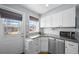 Charming kitchen features white cabinets, granite countertops, and stainless-steel appliances at 2823 Jasmine St, Denver, CO 80207