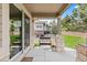 Inviting covered patio featuring stone columns, neutral decor, and a cozy seating area overlooking the backyard at 8216 S Tempe Ct, Aurora, CO 80016
