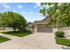 Attractive home exterior showcasing a two-car garage, manicured landscaping, and a well-maintained lawn at 8216 S Tempe Ct, Aurora, CO 80016