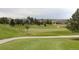 Scenic view of a golf course with green fairways, mature trees, and homes in the background at 8216 S Tempe Ct, Aurora, CO 80016
