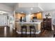 Open kitchen with granite counters, wood cabinets, stainless appliances, and bar stool seating at 8216 S Tempe Ct, Aurora, CO 80016