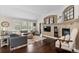 Bright living room with dark hardwood floors, fireplace, and built in TV and display case at 8216 S Tempe Ct, Aurora, CO 80016