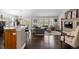 Open-concept living area featuring dark hardwood floors, large windows, kitchen and comfortable seating at 8216 S Tempe Ct, Aurora, CO 80016