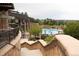 Exterior view of pool area with stone pillars, wrought iron fence, and a building with covered patios at 8216 S Tempe Ct, Aurora, CO 80016