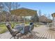 A spacious backyard deck featuring outdoor seating with an umbrella and mature trees at 884 W 124Th Dr, Denver, CO 80234