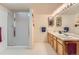Well-lit bathroom featuring a double vanity, framed mirrors, and a stand up shower at 884 W 124Th Dr, Denver, CO 80234