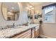 Bright bathroom featuring double sinks, granite countertop, and two decorative mirrors at 884 W 124Th Dr, Denver, CO 80234