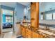 Elegant bathroom featuring double sinks, stunning granite countertop, and wood cabinetry, offering a spa-like experience at 884 W 124Th Dr, Denver, CO 80234