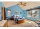 Charming bedroom with vaulted ceiling, large window, and a bed with blue patchwork quilt, creating a cozy retreat at 884 W 124Th Dr, Denver, CO 80234