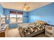 Bright bedroom features a large window, light blue walls, a leafy green bedspread, and a dresser at 884 W 124Th Dr, Denver, CO 80234