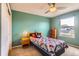 Cozy bedroom with blue walls, large window, and a bed with colorful patchwork quilt, creating a cheerful space at 884 W 124Th Dr, Denver, CO 80234