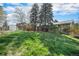 This sprawling backyard features lush greenery, mature trees, and a charming screened in patio at 1244 S Wright St, Lakewood, CO 80228