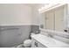This renovated bathroom features a vanity and mirrored medicine cabinet above the sink and integrated shower at 1244 S Wright St, Lakewood, CO 80228