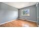 This cozy bedroom features hardwood floors, neutral gray walls, and a sunny window for natural light at 1244 S Wright St, Lakewood, CO 80228