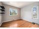 Cozy bedroom with hardwood floors and a bright window offering a view of lush trees at 1244 S Wright St, Lakewood, CO 80228