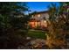 Manicured backyard featuring a stone patio with pergola and fire pit, framed by lush landscaping at 13822 Worthington Pl, Parker, CO 80134