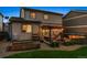 Inviting backyard with stone patio, a pergola with cafe lights, and fire pit perfect for entertaining at 13822 Worthington Pl, Parker, CO 80134
